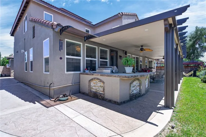 right side of home and view of the custom BBQ outdoor kitchen space