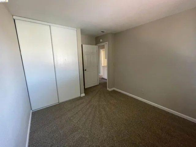 Neutral-toned walls complement the brown carpet flooring