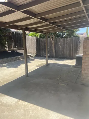 Covered patio area featuring a corrugated metal roof and supporting posts