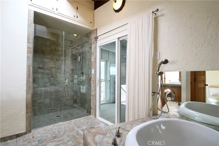 Main bathroom, tiled shower, jetted tub and slider to stairway to indoor pool