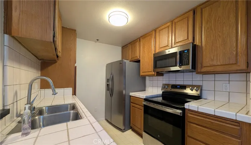 Kitchen with electric stove, microwave, dishwasher, and refrigerator