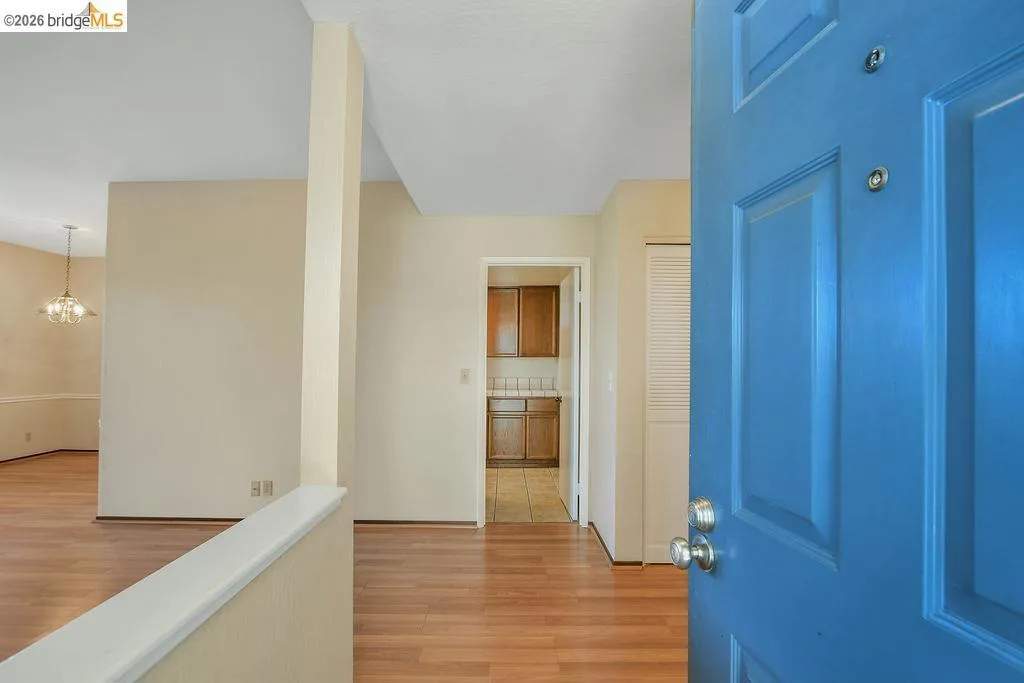 Entryway featuring a paneled door, wood-finish flooring, and neutral wall tones