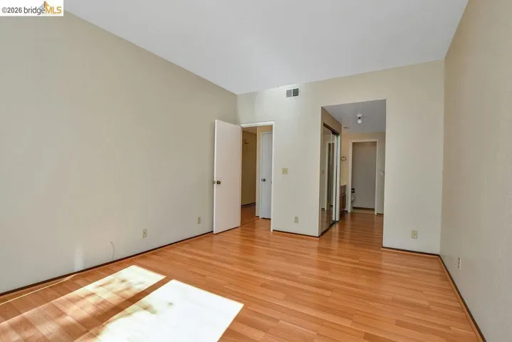 Spacious room featuring wood-finish flooring, neutral-toned walls, and recessed lighting