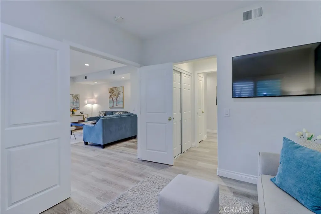 Dual entry doors open to the Secondary primary bedroom showing the hallway to the attached bathroom and closet.