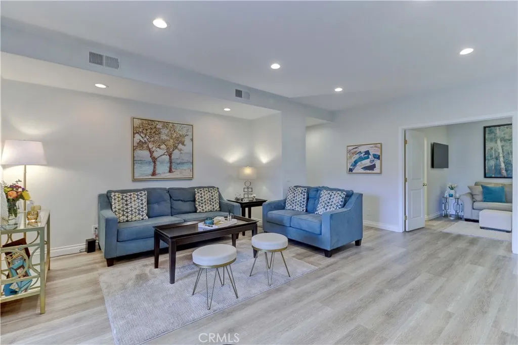 Living room with recessed lighting and newer vinyl flooring.