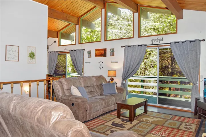 Welcome Home to 23641 Manzanita Drive with fabulous newer flooring on the 2nd level which offers gorgeous wood beam vaulted ceilings, a wall full of windows, a cozy rock fireplace, a freshly painted full length deck to enjoy the treehouse-style views, a new mini split system with AC/heat/dehumidifier to keep you comfortable year-round, new dual-paned windows on the 1st floor, and a large fenced backyard!