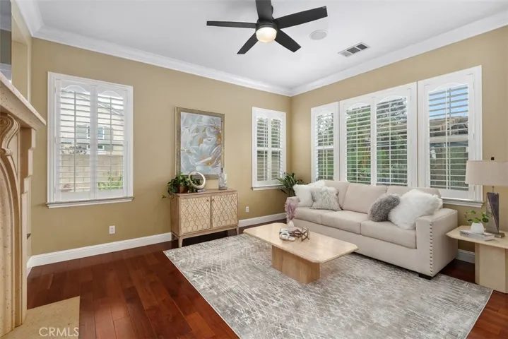 Living room with ceiling fan and shutters