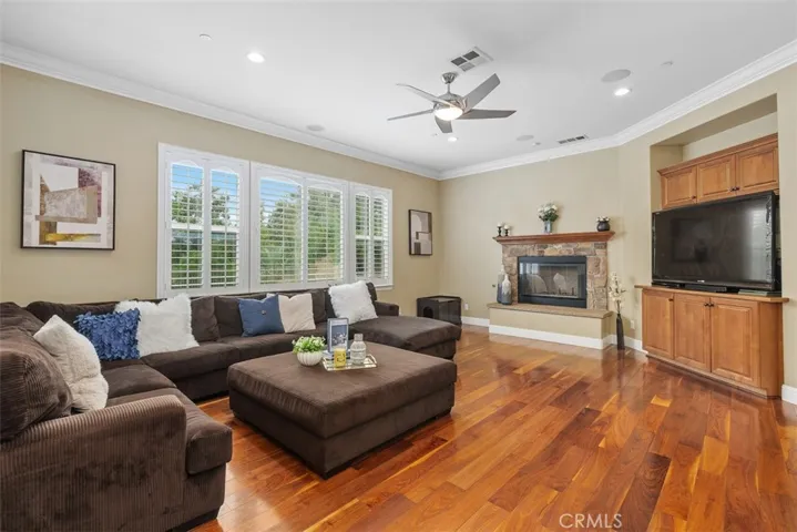 Family room with ceiling fan and a third fireplace