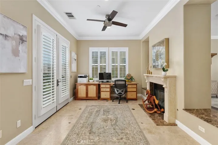 Library with ceiling fan, double French doors & marble fireplace