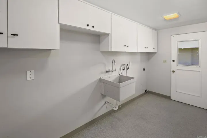 Laundry room with outside door.  Serves as utility room and storage area.