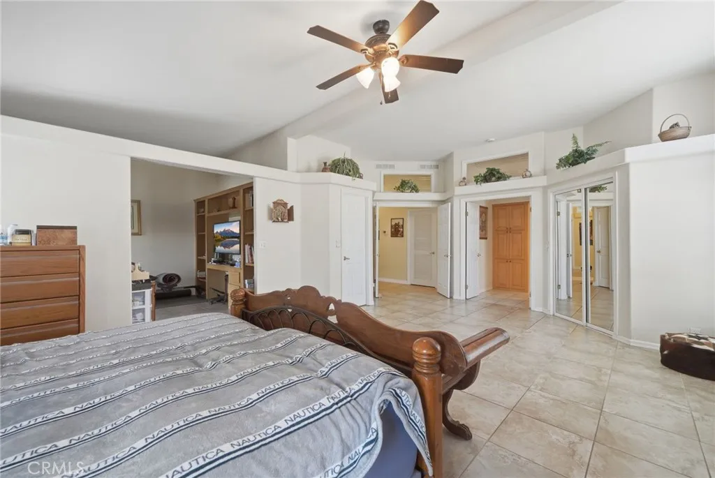 Primary bedroom w mirrored sliding doors at one closet to right and walk in closet thru door at left. Office space or retreat of 4th bedroom to the left.