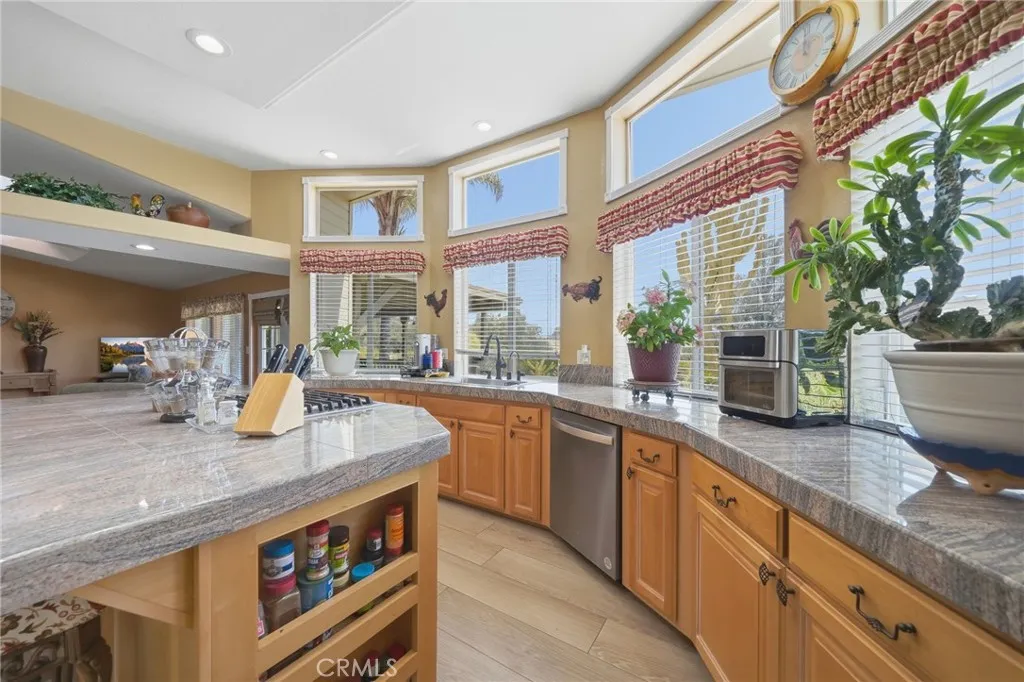 Kitchen w smart storage and brand new dishwasher w windows overlooking the rear of property
