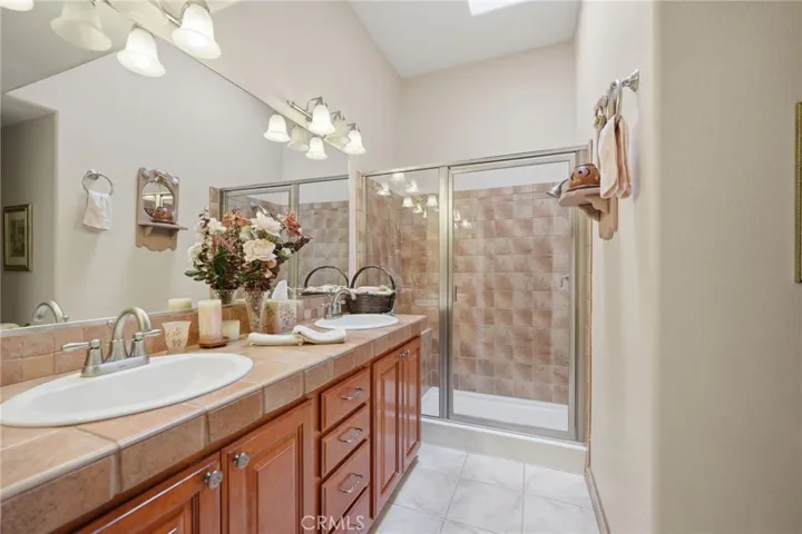 Hall bathroom w walk in shower, dual sinks and skylight for natural light