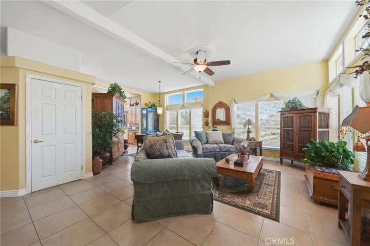Living room w tile flooring, custom paint and ceiling fan/light fixture.