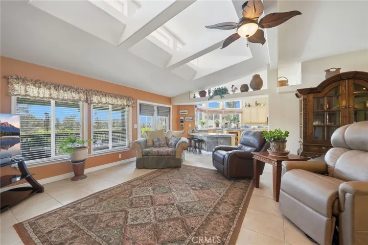 HUGE great room w upper windows for additional illumination, tiled flooring and windows overlooking back patio and pool