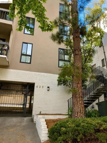 Multi-story building exterior featuring a beige stucco facade and black-framed windows