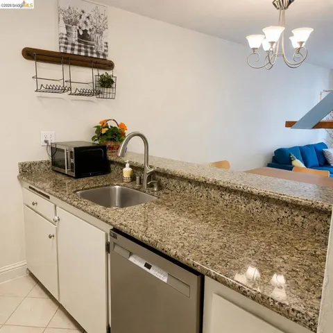 Kitchen area featuring a stainless steel sink, a high-arc faucet, and granite countertops