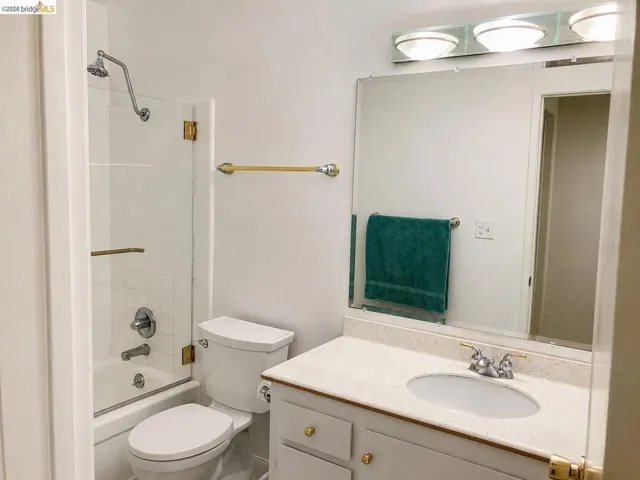 Bathroom featuring a white vanity with a light-colored countertop, an undermount sink, and a large wall-mounted mirror