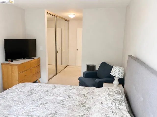 Carpeted room featuring mirrored closet doors and a flush-mount ceiling light fixture