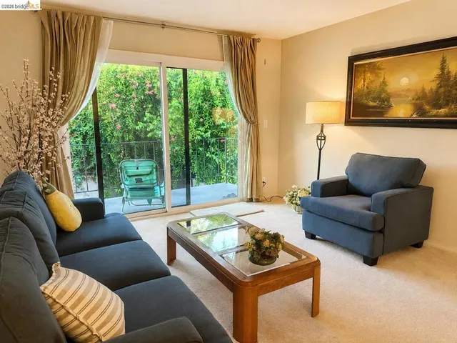 Living space featuring wall-to-wall carpeting, light-toned wall paint, and a large sliding glass door