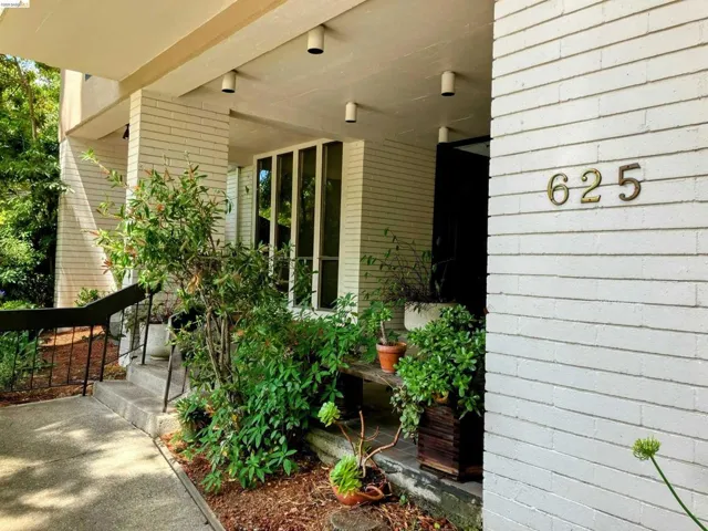 White brick facade with prominent brass house numbers