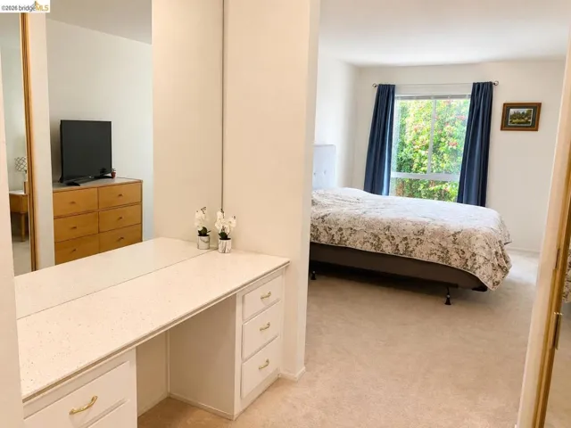 Built-in vanity with a speckled countertop and gold-tone drawer pulls, offering integrated storage