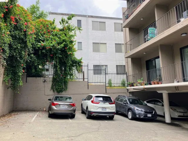 Outdoor parking area with paved surface, multiple parking spaces, and a concrete retaining wall