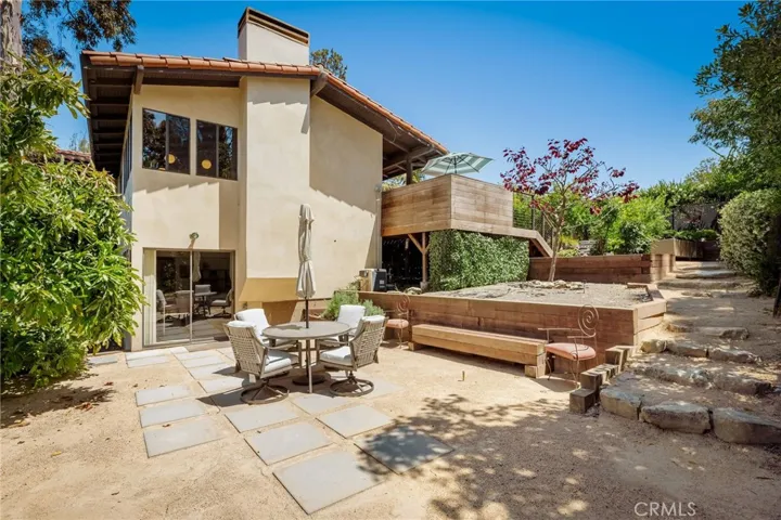 Lower yard seating area with avocado tree and plantar beds