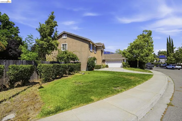 Residential exterior with stucco siding, a two-car garage, and a concrete driveway