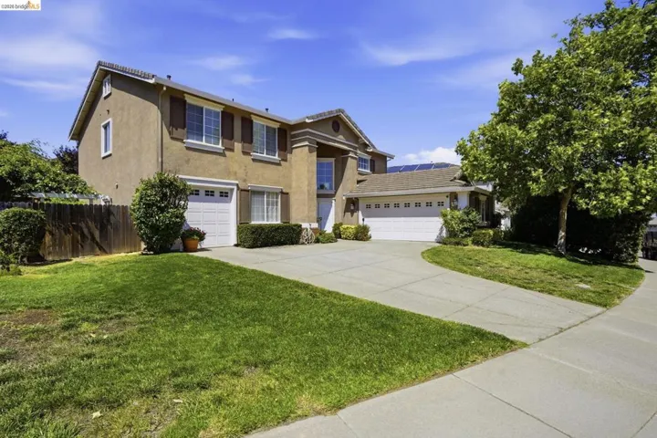 Two-story exterior with stucco siding and multiple white garage doors