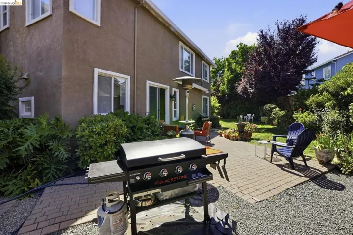 Exterior patio featuring paver stones, gravel, and mature landscaping