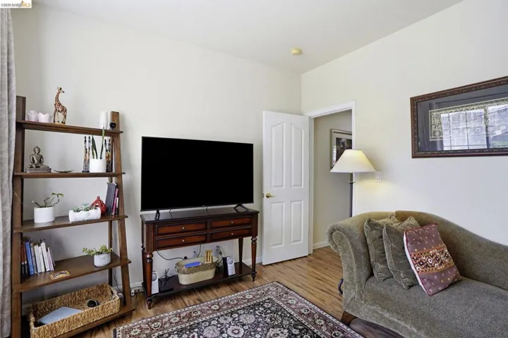 Room featuring wood-finish flooring, light-colored walls, a classic paneled door, and recessed lighting