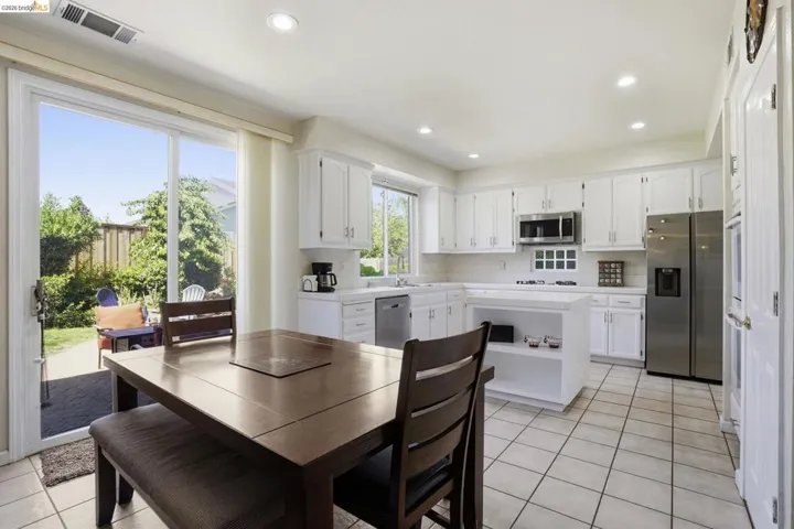 Kitchen featuring white cabinetry, stainless steel appliances, recessed lighting, and tile flooring