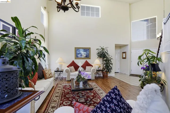 Vaulted living room featuring wood-finish flooring and a decorative chandelier