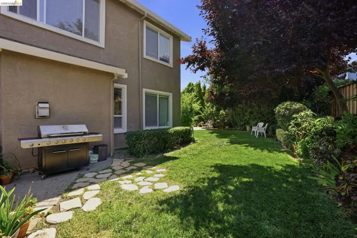 Expansive backyard featuring a lush lawn, mature trees, and established shrubbery