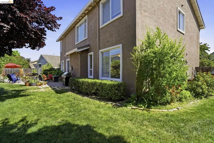 Expansive lawn area and stucco exterior with multiple windows