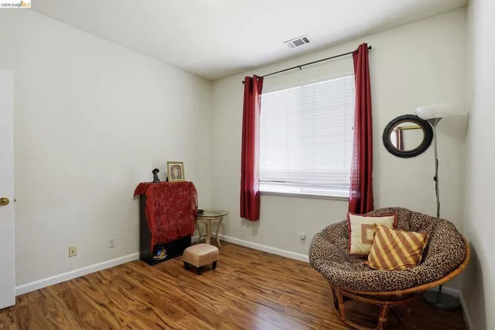 Room featuring wood-finish flooring, white baseboards, and neutral wall tones