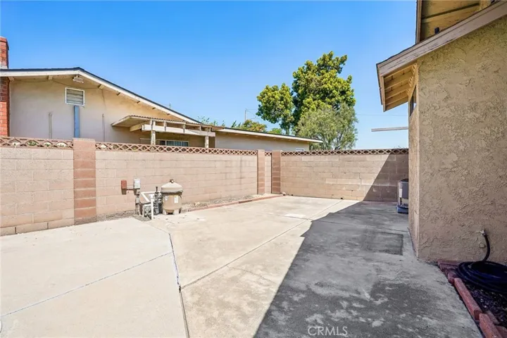 Back Patio Area - The added patio area offers an expansive outdoor space with endless potential for entertaining, recreation, or additional lounge seating alongside the sparkling pool. The oversized concrete deck provides plenty of room for outdoor dining, BBQs, or creating a customized backyard retreat. Surrounded by block wall fencing for privacy and featuring direct access to the home and covered patio area, this versatile space is ideal for enjoying Southern California outdoor living year-round.