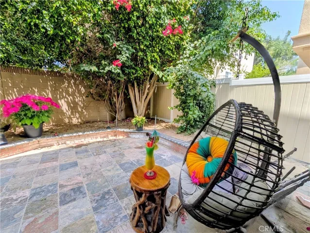 Relaxing backyard with Slate patio and lush trees. (This image has been virtually staged to illustrate the potential use of space. Furnishings, finishes, and décor shown may not exist in the home and are not included in the sale.)