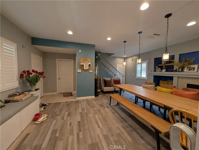 Modern grey-toned laminate wood flooring flows throughout the main level, complemented by recessed lighting, upgraded plantation shutters, and sophisticated finishes that create a warm contemporary ambiance