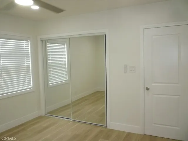 Bedroom one of two with mirrored sliding closet doors, recessed lighting and ceiling fan.