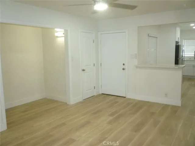 Another view of the living room with recessed lighting and ceiling fan.
