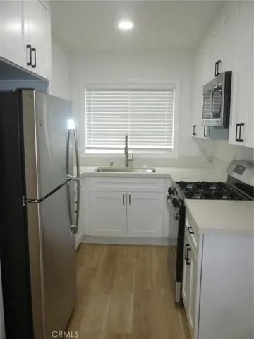 Galley kitchen with recessed lighting, new dual pane vinyl windows, stainless appliances, vinyl plank flooring throughout the unit and a microwave oven/hood that vents outside.