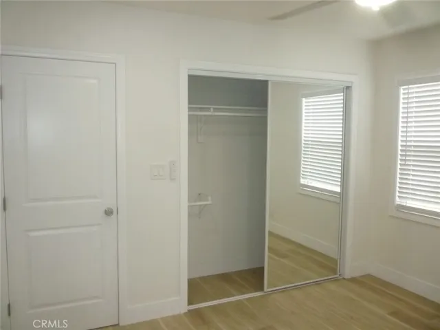 Bedroom two of two with mirrored sliding closet doors, recessed lighting and ceiling fan.