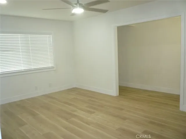 Another view of the living room with vinyl plank flooring throughout the unit.  Storage area is to the right.