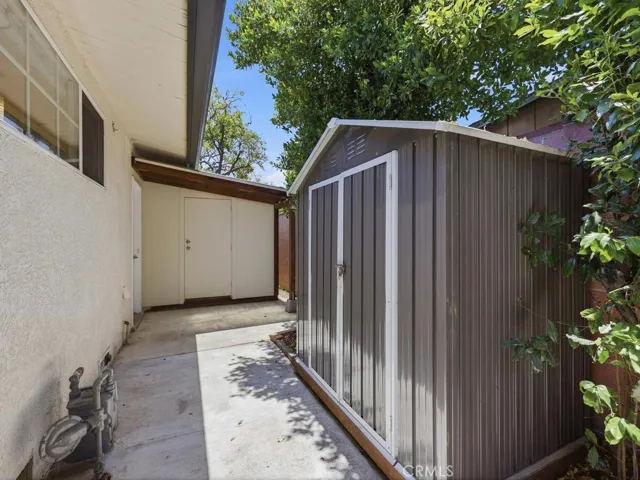 2 Side yard sheds, one is attached to garage with cover over side garage door.