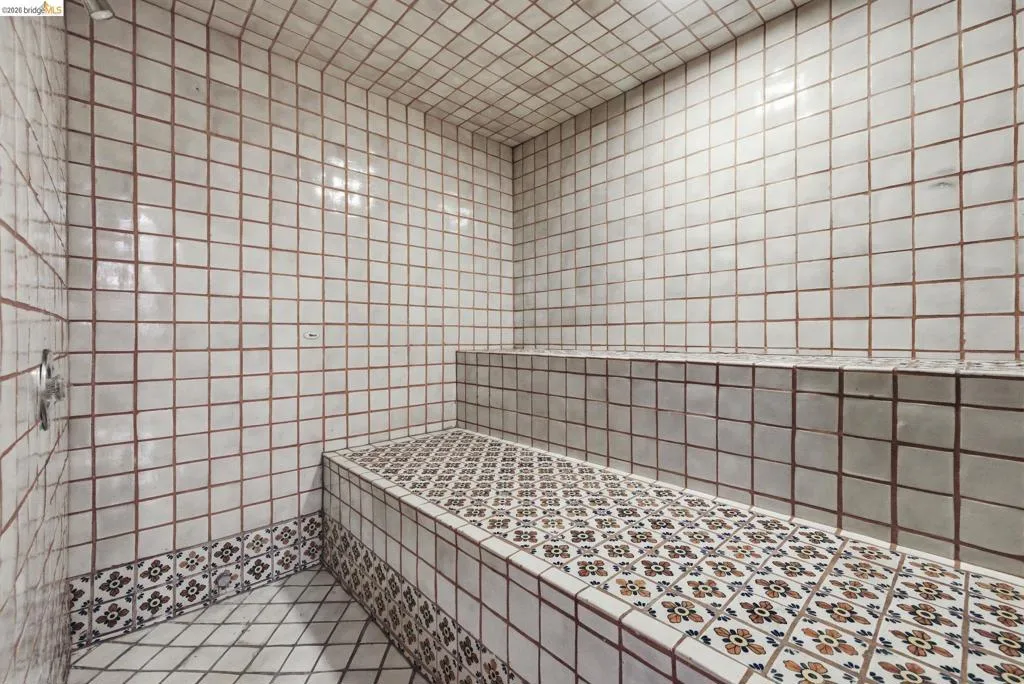Private steam room with full floor-to-ceiling tile surround and bench seating. A standout amenity — uncommon in Twain Harte mountain homes at this price point.