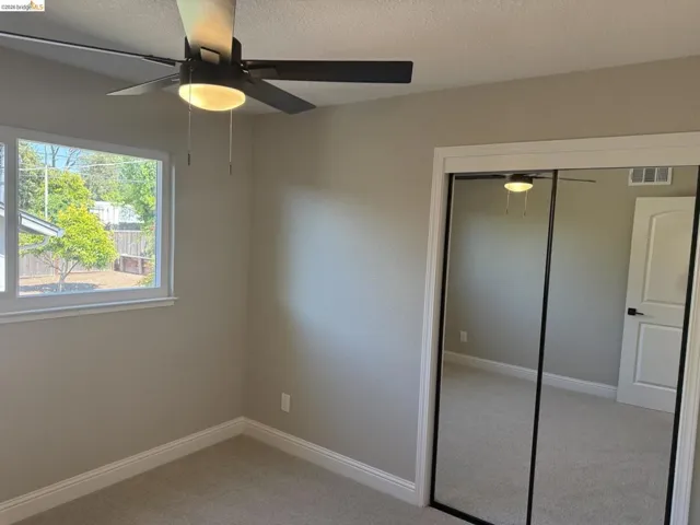 Interior room featuring light gray wall paint, white baseboards, and light-colored carpeting