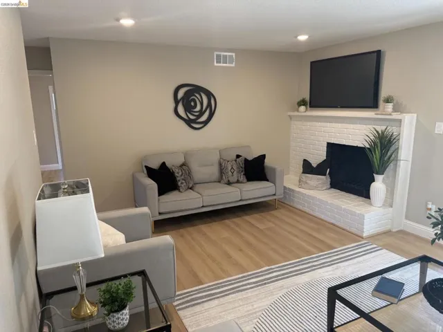 Light wood-finish flooring complements neutral wall tones and recessed lighting
