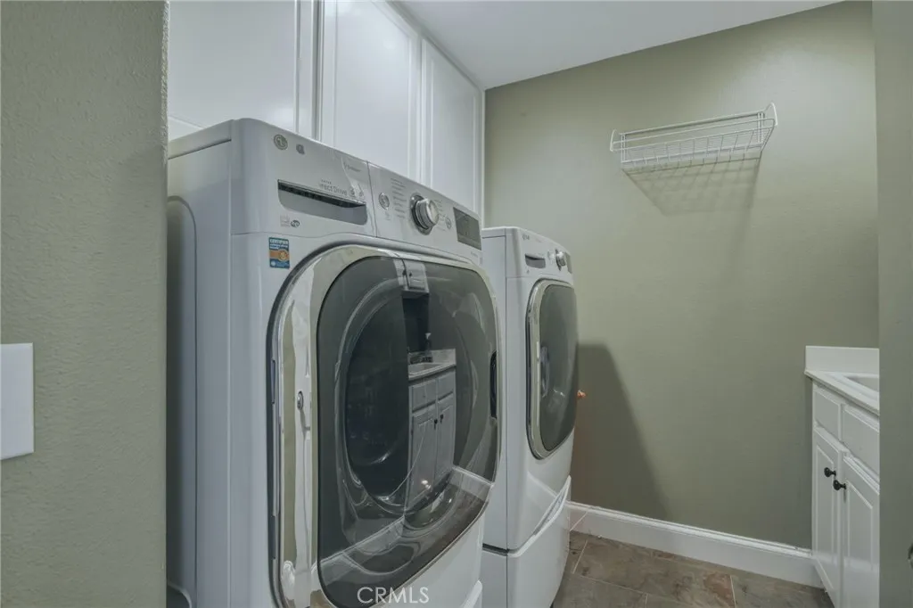 Laundry room with built-in cabinetry, utility sink, and convenient storage space for everyday household needs